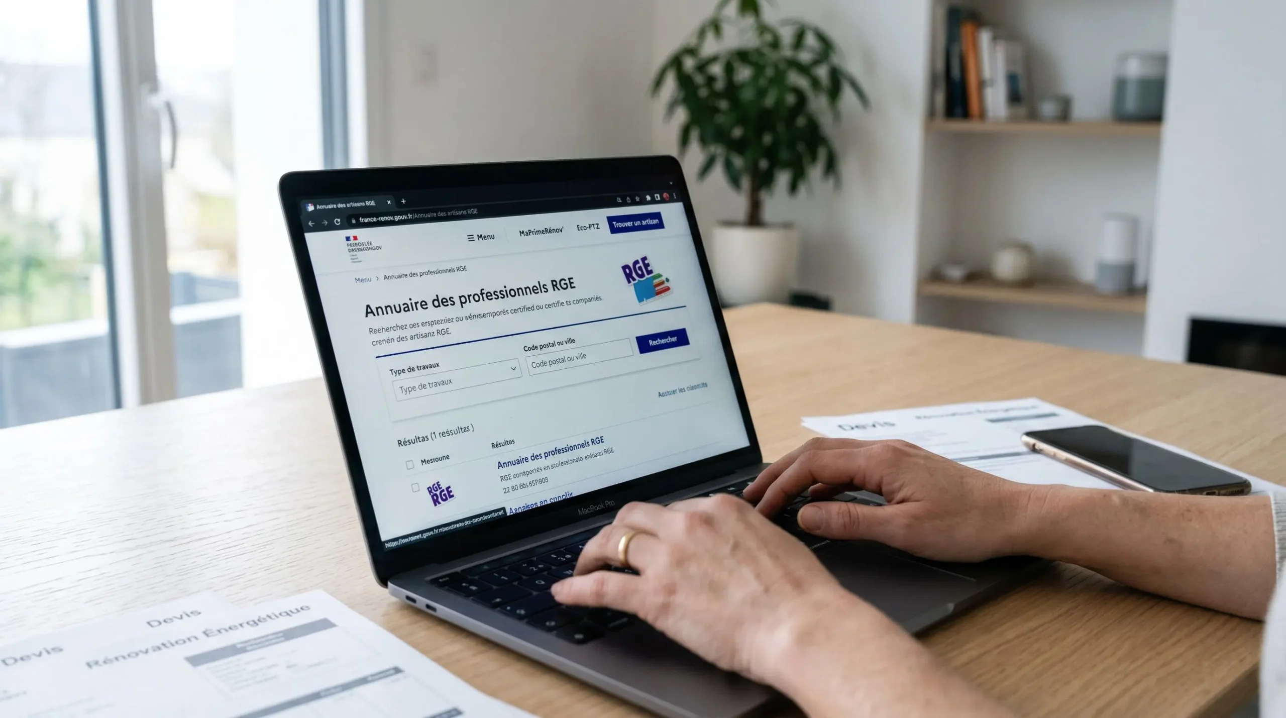 Écran ordinateur affichant site france-renov.gouv.fr avec annuaire entreprises RGE, mains tapant sur clavier pour vérifier certification